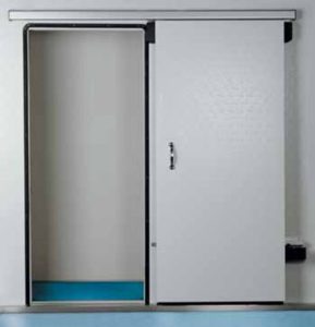 The image shows a commercial sliding cold room door that is partially open, revealing the interior of a walk-in refrigerator or freezer with white walls and a blue floor strip.